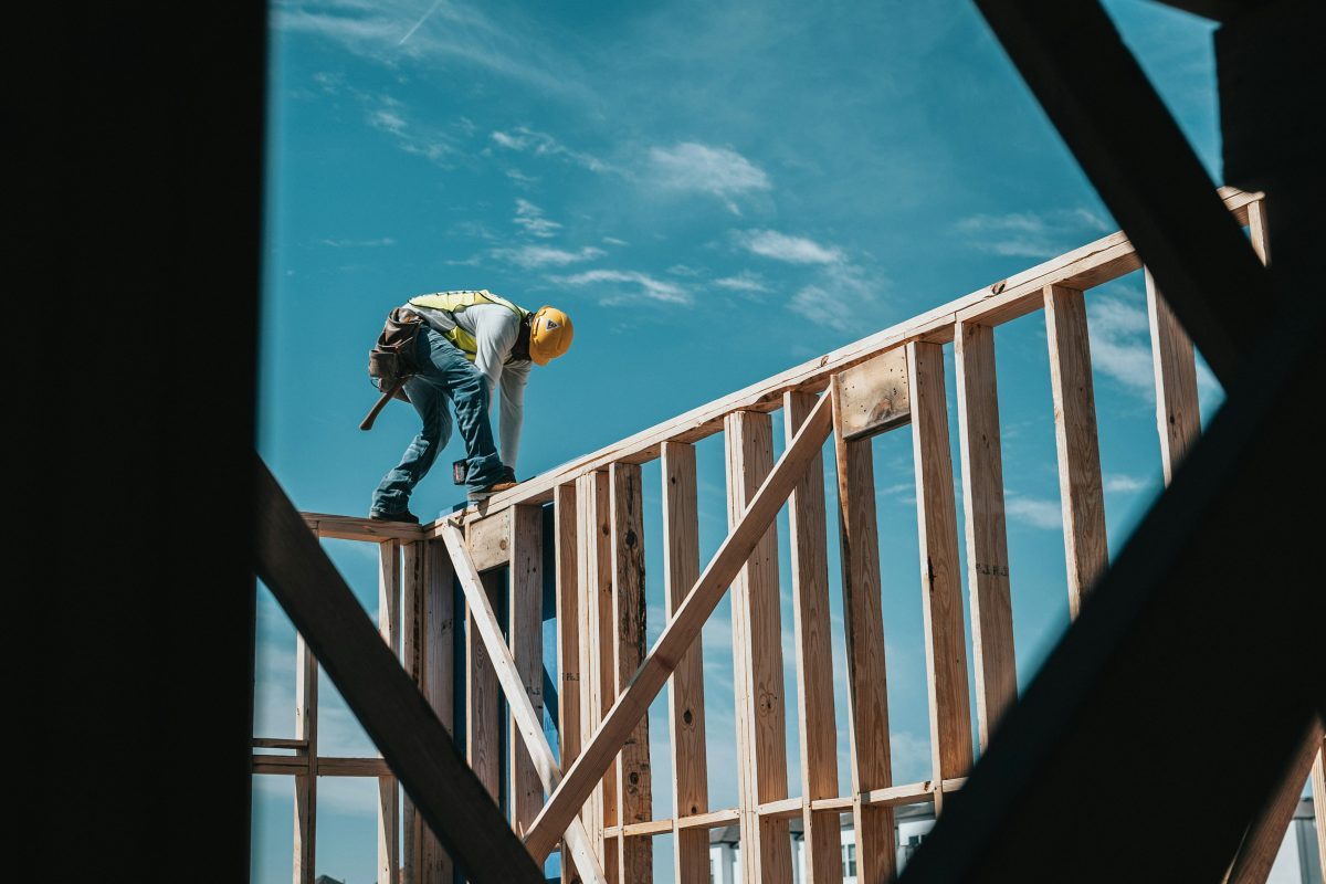 Construction worker standing on a partially built foundation at a development site